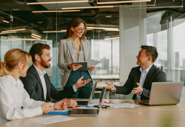 Smiling colleagues in an informal office meeting celebrating successful software testing.