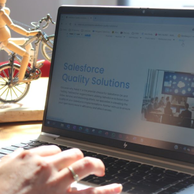 A person using a laptop to review the Nekst IT website, representing Salesforce quality assurance and seamless system integration.